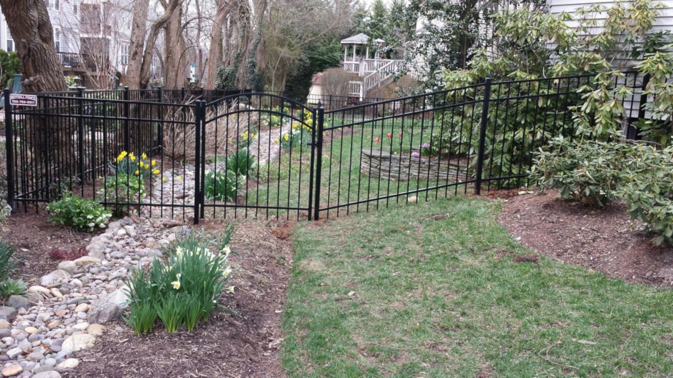 black aluminium fence The black gate stands in the garden.